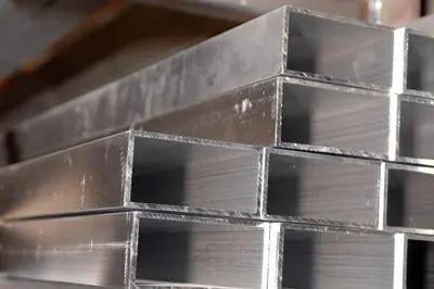 Close-up of stacked metal rectangular tubes with clean-cut edges, arranged in parallel rows.